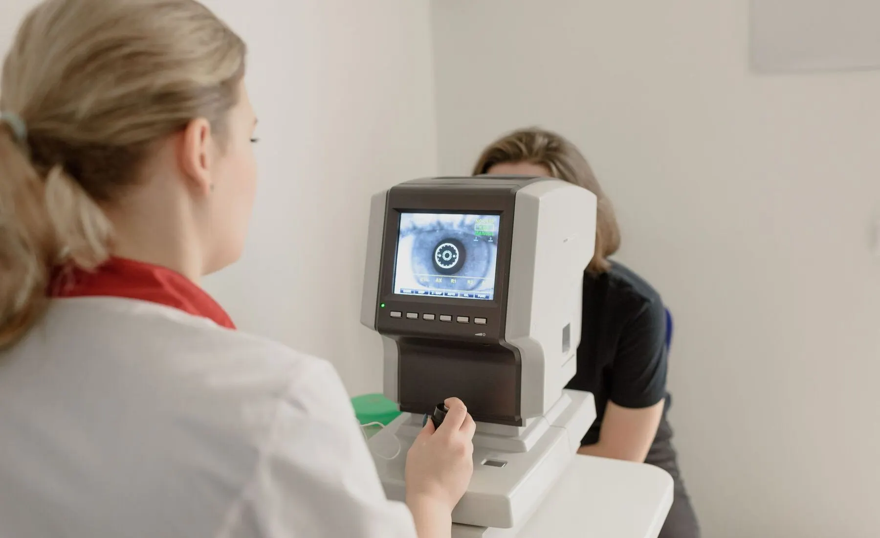 Optometrist capturing a retinal image of a patient with a digital eye scanner