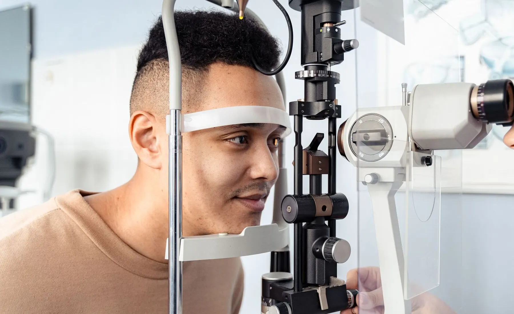 Patient seated at a slit lamp during an eye surface assessment