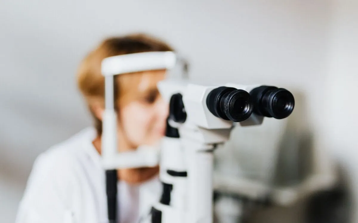 Patient seated at a slit lamp while the eye is examined