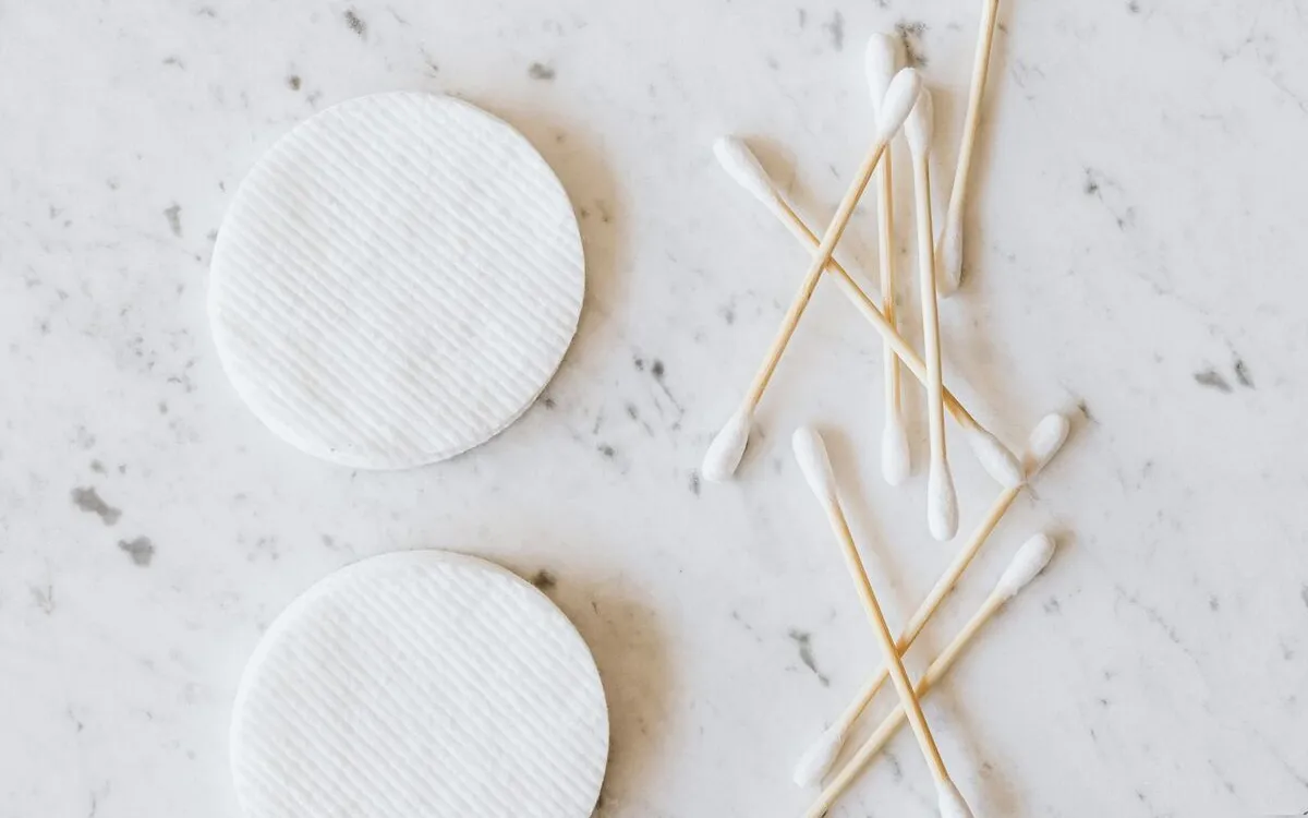 Cotton pads and cotton buds on a white marble surface