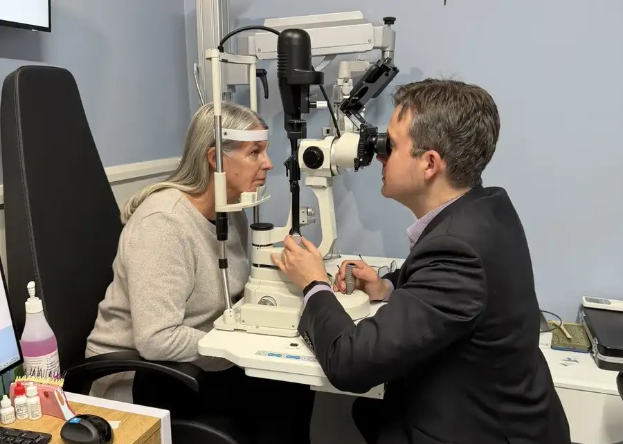 Leigh Plowman examining a patient at a slit-lamp microscope